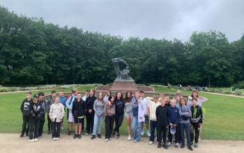 Powiększ obraz: uczniowie przed pomnikiem Fryderyka Chopina w Lazienkach Krolewskich
